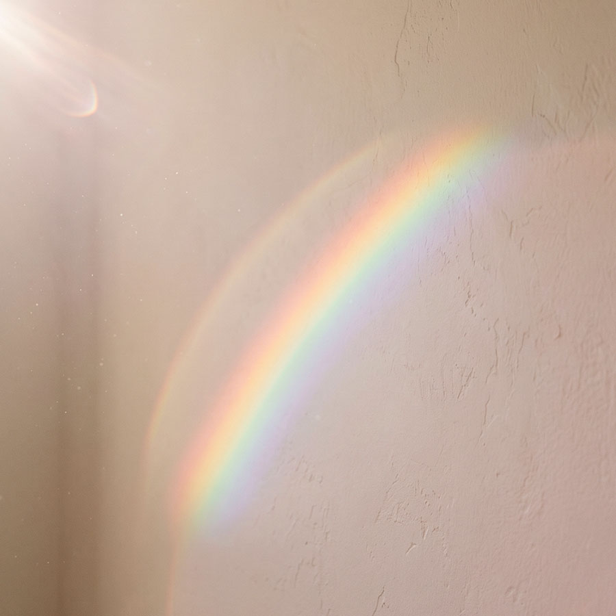 Regenbogenlicht fällt auf eine helle Wand